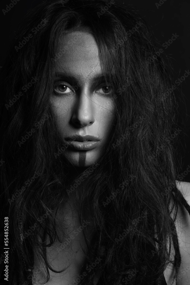 Beauty and make-up concept. Beautiful woman studio portrait. Model with messy dreadlocks hair and make-up looking to camera with seductive look. Black and white image