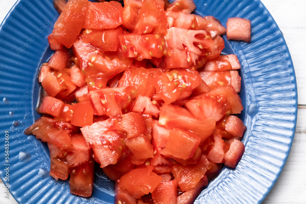 Sliced tomato on a blue plate. Fresh tomato without peel. Sliced tomato on a blue plate. Fresh tomato without peel.