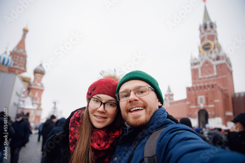 Friends make winter silfie photo woman and man background red square. Concept travel Russia Christmas holidays kremlin