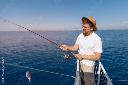 Tour fishing Turkey, Fisherman hipster tourist hold fish red mullet on boat in sea