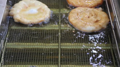 Street food vendor is preparing the Pancakes in hot oil until crispy on the outside.