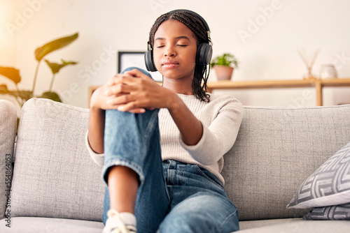 Music headphones, peace and relax girl listening to wellness podcast for calm mindset, mindfulness or audio meditation. Easy meditating, living room sofa or gen z black woman streaming zen radio song photo