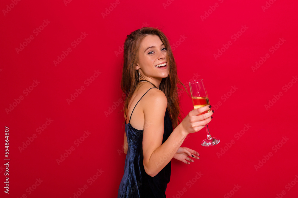 Incredible stylish happy girl with wonderful smile wearing blue holiday dress holding a glass go wine and posing over red background. Incredible stylish happy girl with wonderful smile wearing blue holiday dress holding a glass go wine and posing over red background.
