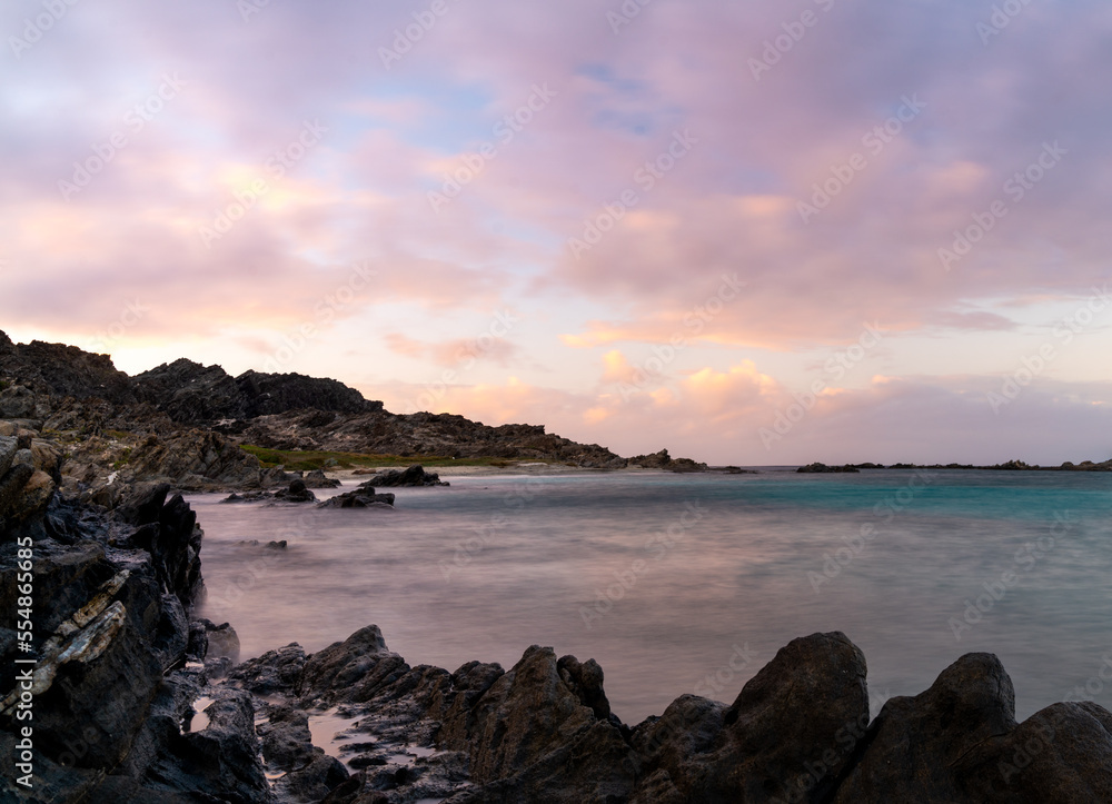 sunset seascape with rocks and reef at Capo Falcone in Sardinia