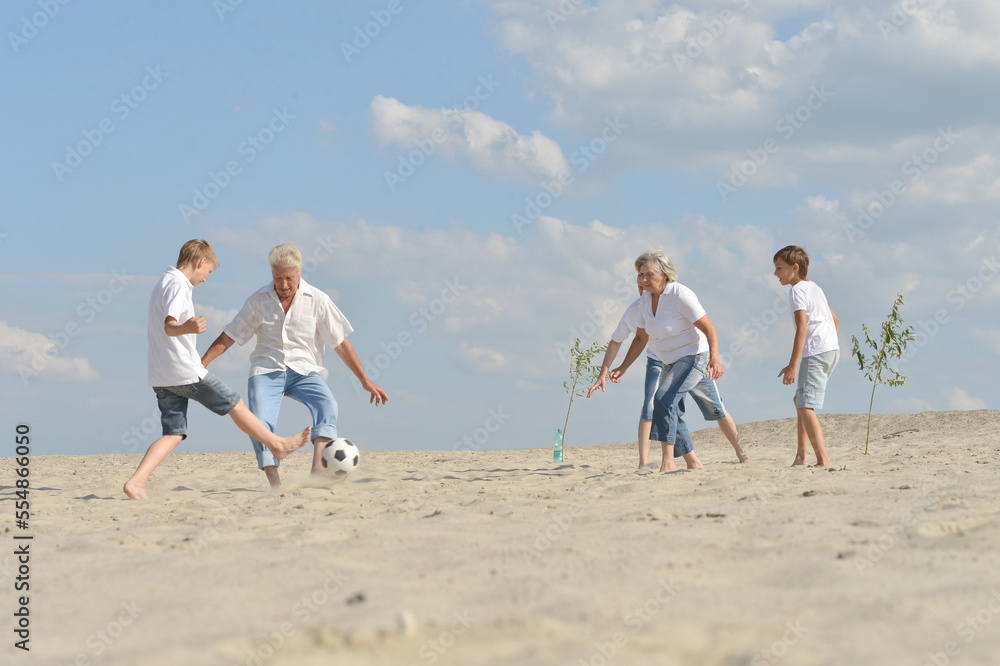 Family playing football on a beach in summer day Family playing football on a beach in summer day