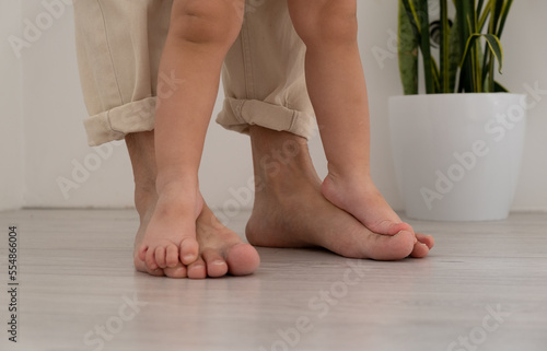 Beautiful young family. Bare feet of father and daughter.
