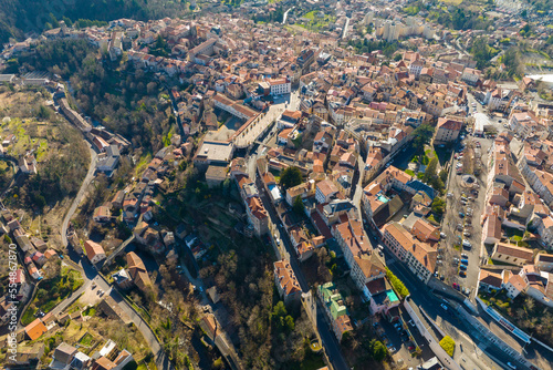 Aerial view of dense historic center of Thiers town in Puy-de-Dome department, Auvergne-Rhone-Alpes region in France. Rooftops of old buildings and narrow streets © bilanol