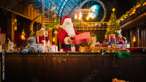 Jolly Santa Claus in His Studio Workshop: Wrapping and Packing Christmas Gifts for all the Good Children to be Delivered on the Magical New Year Eve. He Prepares the Gifts this Winter Holiday