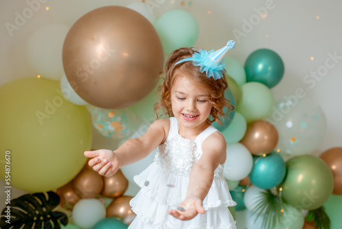 little girl celebrating birthday catches confetti