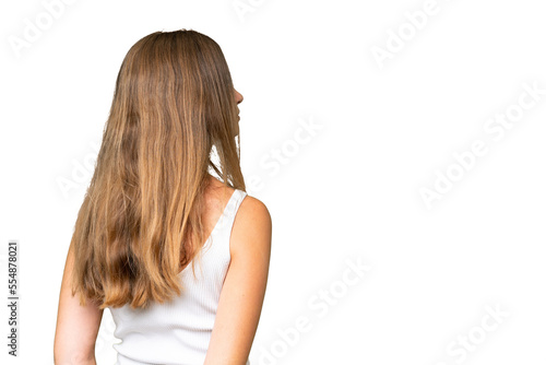 Young pretty woman over isolated background in back position and looking back
