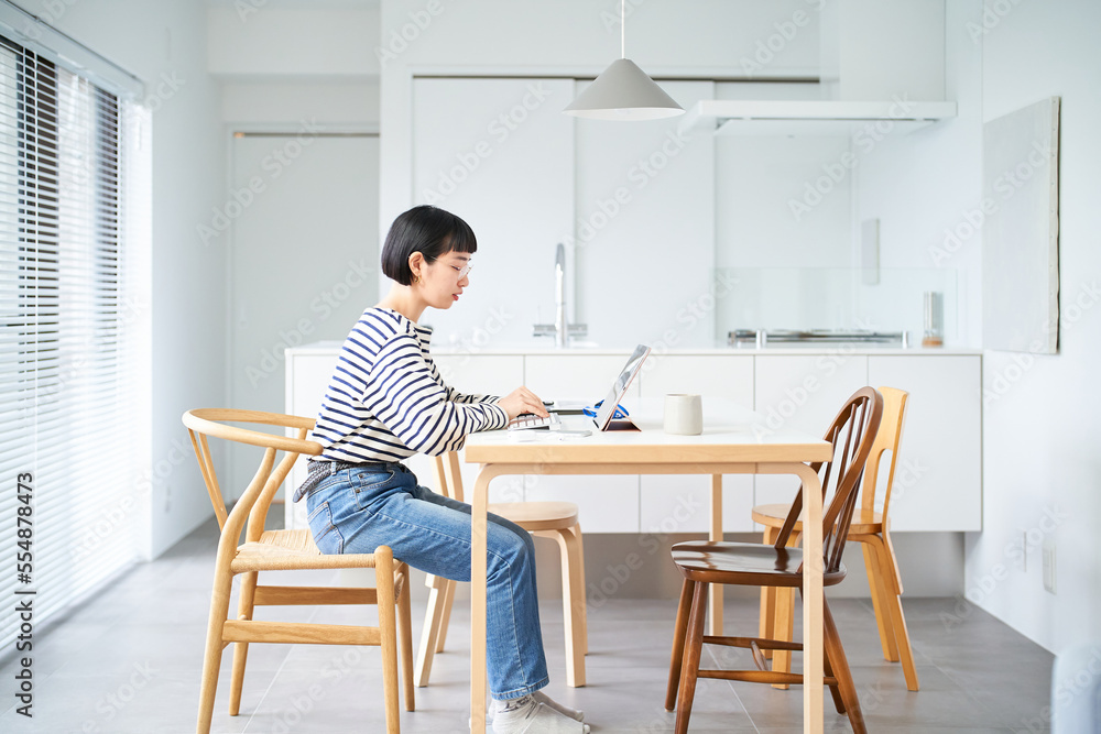 部屋のテーブルで仕事をする若い女性 部屋のテーブルで仕事をする若い女性