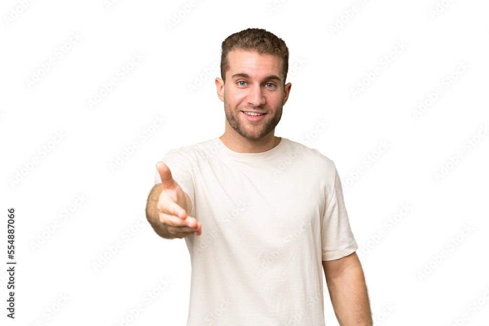 Young handsome caucasian man isolated on green chroma background shaking hands for closing a good deal Young handsome caucasian man isolated on green chroma background shaking hands for closing a good deal