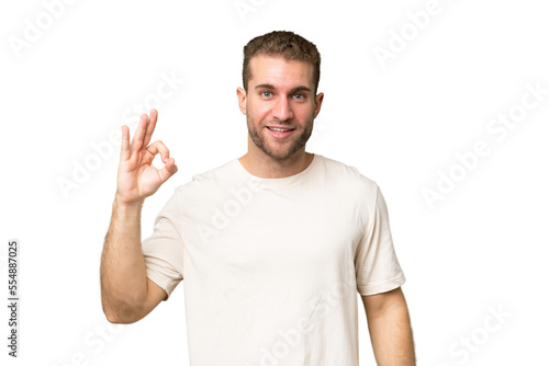 Young handsome caucasian man isolated on green chroma background showing ok sign with fingers