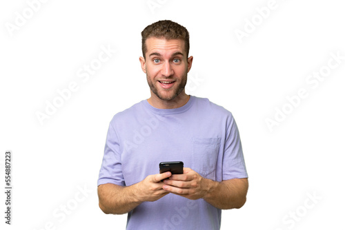 Young handsome caucasian man isolated on green chroma background surprised and sending a message © luismolinero