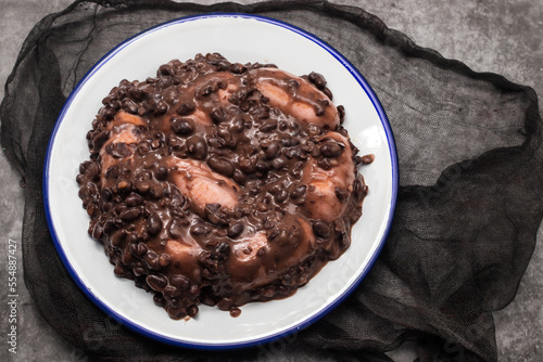 black beans stew with sausages on a white dish