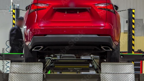 Car on stand with sensors on wheels for wheels alignment camber check in workshop of Service station timelapse. Car moves on lift