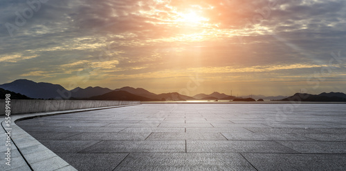 Empty square floor and mountain with sea at sunset