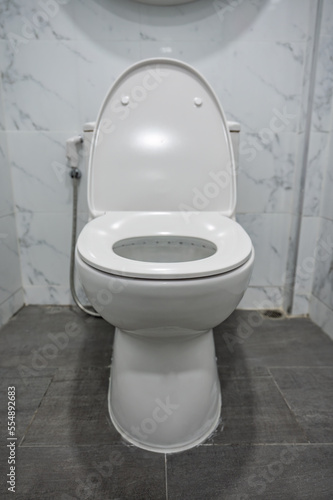 White ceramic flush bowl with open lid in toilet