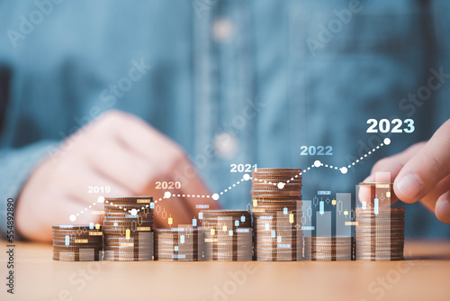 Fototapeta Businessman stacking money coins with up arrow and percentage symbol for financial banking increase interest rate or mortgage investment dividend from business growth concept