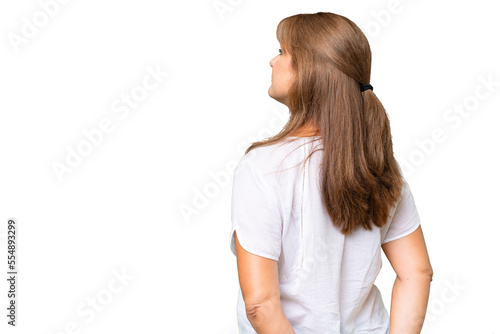 Middle-aged caucasian woman over isolated background in back position and looking back