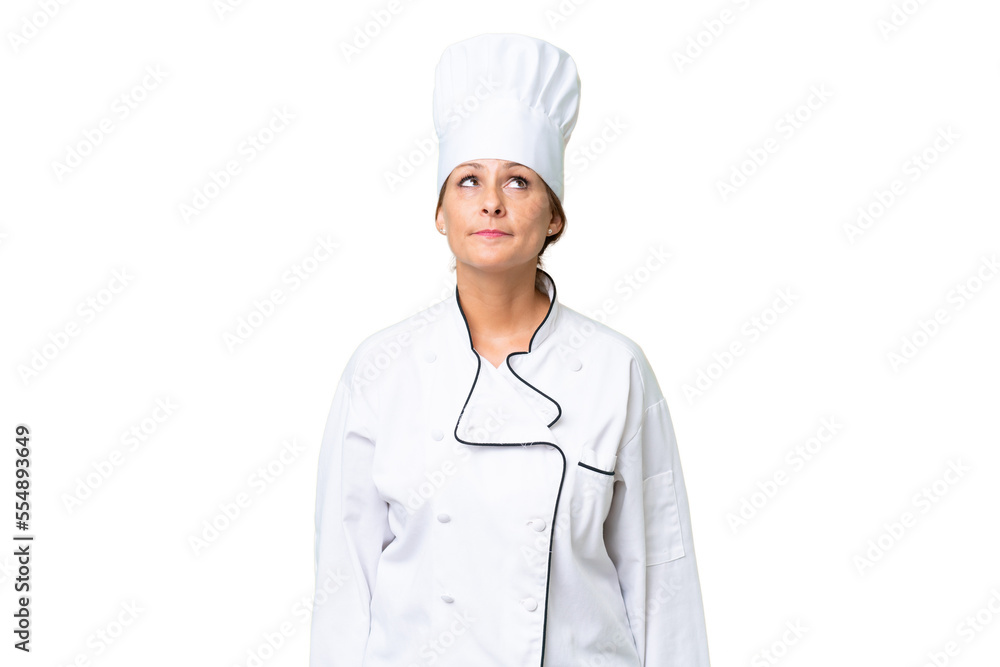 Middle-aged chef woman over isolated background and looking up Middle-aged chef woman over isolated background and looking up