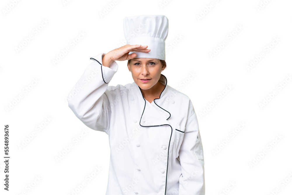 Middle-aged chef woman over isolated background looking far away with hand to look something Middle-aged chef woman over isolated background looking far away with hand to look something