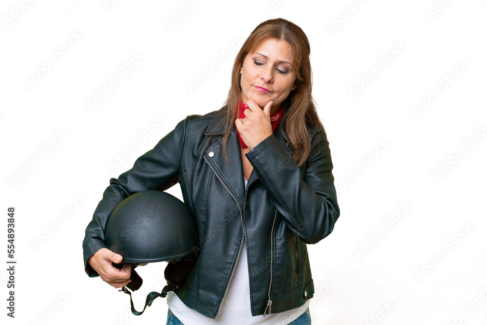 Middle-aged caucasian woman with a motorcycle helmet over isolated background looking to the side and smiling Middle-aged caucasian woman with a motorcycle helmet over isolated background looking to the side and smiling
