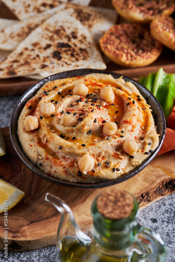 Hummus and vegetables on wood slab Hummus and vegetables on wood slab