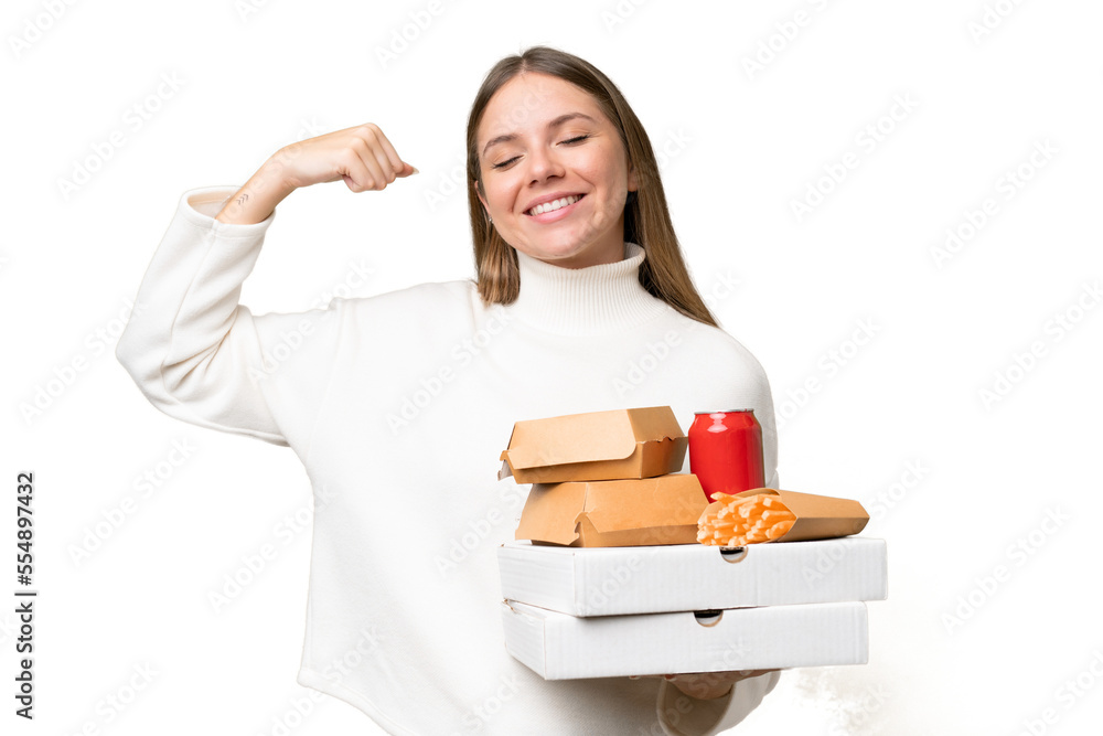 Young beautiful blonde woman holding takeaway food over isolated background doing strong gesture Young beautiful blonde woman holding takeaway food over isolated background doing strong gesture