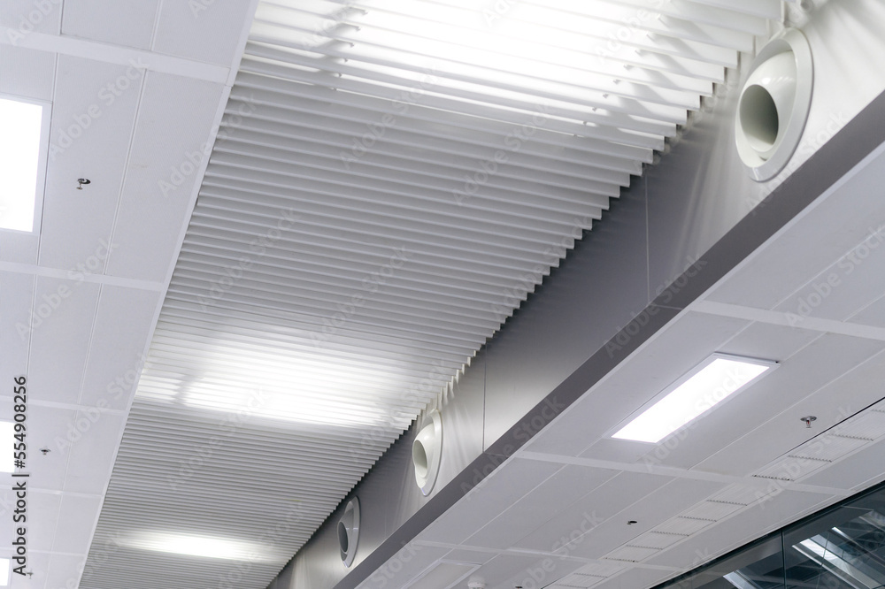 Obraz premium Ceiling mounted cassette type air conditioner and modern lamp light on white ceiling. duct air conditioner for home or office