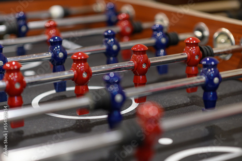Close-up plastic players in table football in entertainment center. Soccer table with red and blue players. © bigy9950