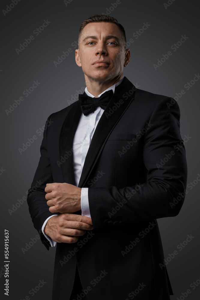 Studio shot of agent man dressed in black suit looking at camera. Studio shot of agent man dressed in black suit looking at camera.