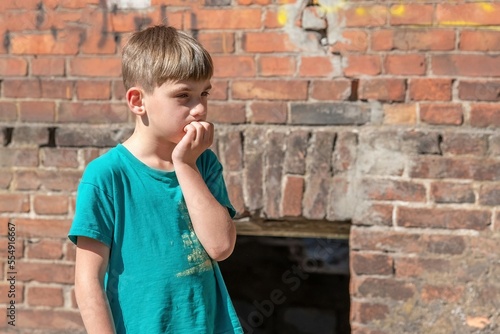 Children in an abandoned and destroyed building in the zone of military and military conflicts. The concept of social problems of homeless children. Staged photo.