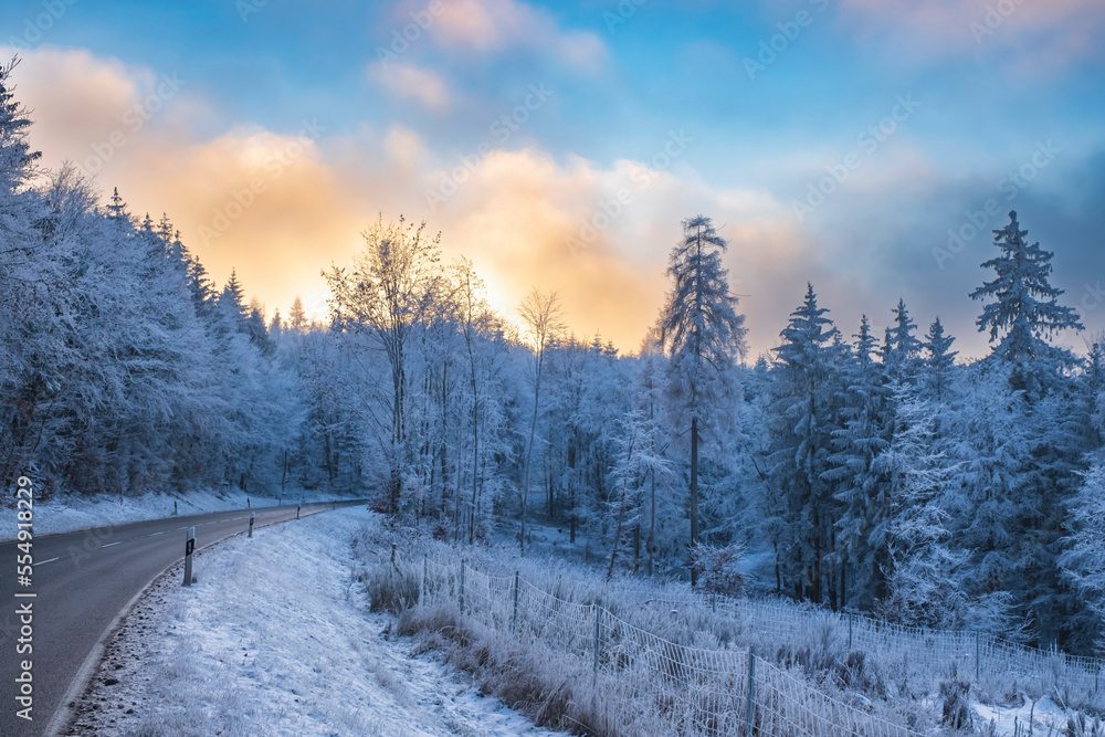 Road through the wintry Taunus in the evening