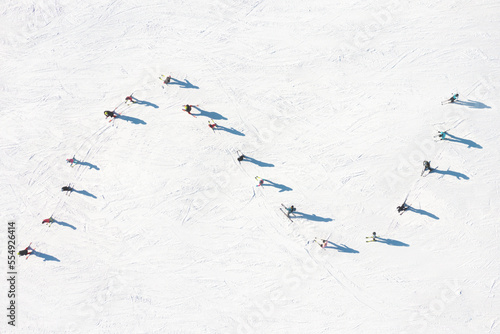 Ski resort. An aerial view of the ski team. Winter sports. Snow slope in the mountains for sports. Group training. Exercise with friends. winter landscape from a drone. photo