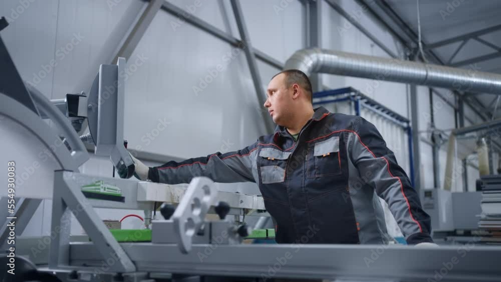 operator of CNC machine for cutting boards in woodworking workshop, adjusting modern equipment operator of CNC machine for cutting boards in woodworking workshop, adjusting modern equipment