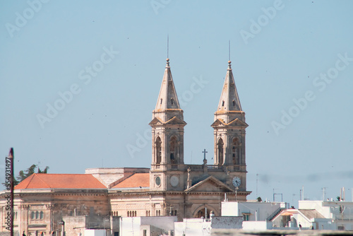 Campanarios de la Basílica santuario de San Cosme y Damián en Alberobello, Italia. Tejados y azoteas de los edificios que rodean el templo cristiano. photo
