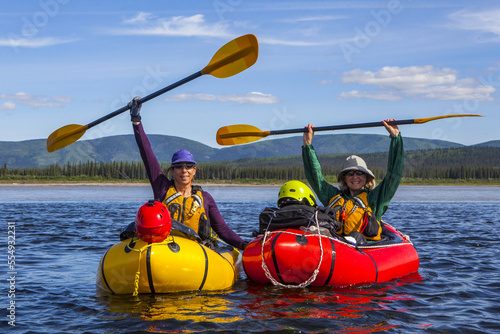 Two women celebrating the end of a successful packraft trip on the Yukon River, Yukon–Charley Rivers National Preserve; Alaska, United States of America photo