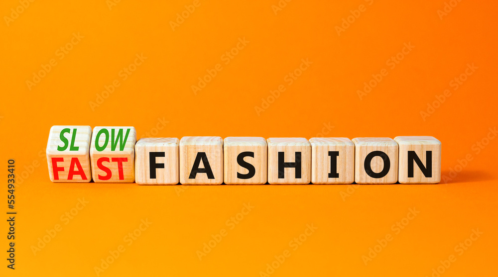 Fast or slow fashion symbol. Concept words Fast fashion and Slow fashion on wooden cubes. Beautiful orange table orange background. Business fast or slow fashion concept. Copy space. - obrazy, fototapety, plakaty 