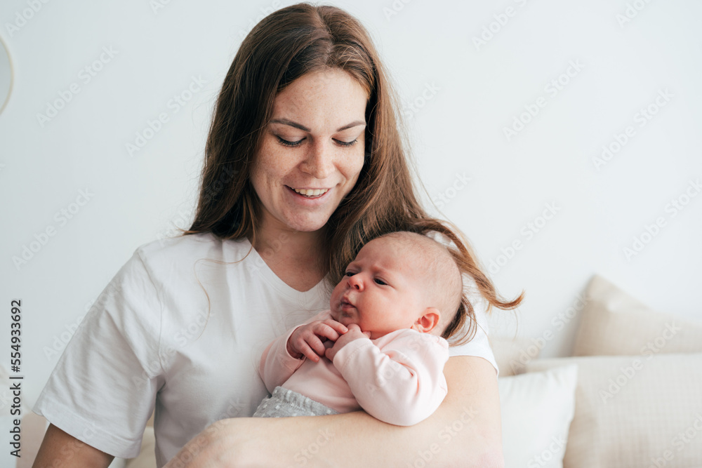 Gentle caring mother holds a newborn baby in her arms. Gentle caring mother holds a newborn baby in her arms.