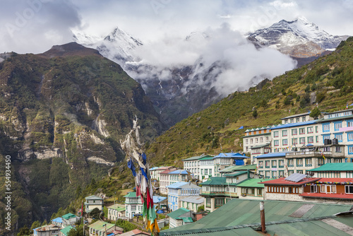 View of Namche Bazaar and the snow dusted Himalayan peaks in the distance, up valley, Sagarmatha National Park, Solokhumbu district, Nepal on an autumn day; Namche Bazaar, Solokhumbu district, Nepal photo