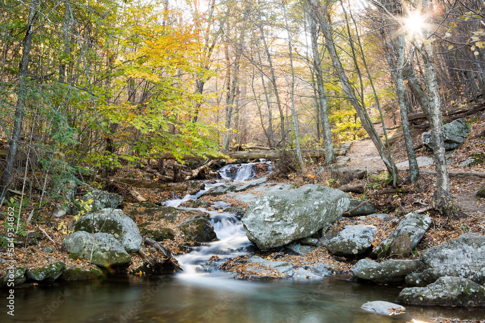 The sun bursts through colorful autumn foliage and a waterfall meanders around rocks along Dark Hollow Falls Hiking Trail in Shenandoah National Park.; Gobi Gurvansaikhan National Park, Virginia, Unit The sun bursts through colorful autumn foliage and a waterfall meanders around rocks along Dark Hollow Falls Hiking Trail in Shenandoah National Park.; Gobi Gurvansaikhan National Park, Virginia, Unit