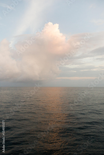 On the water near Caletas Reserve, Osa Peninsula, clouds take on color during sunrise.; Costa Rica