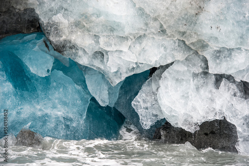 Abstract shapes of glacial ice beside the waves of the Southern Ocean; South Georgia Island, Antarctica photo