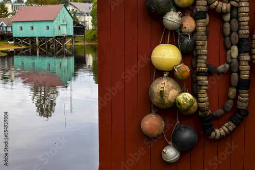 Wooden buoys hang outside of a boathouse. photo