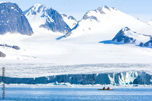 Kayakers explore Hornsund Fjord and view of majestic seaside mountains photo