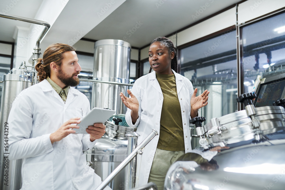Obraz premium Diverse team of technologists checking equipment at brewery