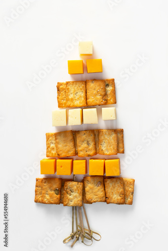 Christmas snack with cheese and crackers in the form of a Christmas tree on a white background