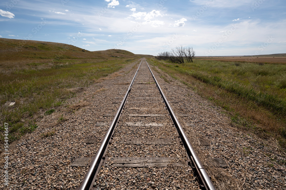 Railroad tracks on a vast landscape of the Canadian prairies leading into the distance; Sanctuary, Saskatchewan, Canada Railroad tracks on a vast landscape of the Canadian prairies leading into the distance; Sanctuary, Saskatchewan, Canada