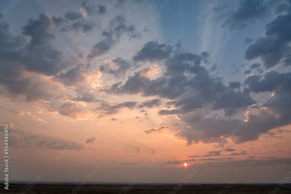 Beautiful sunrise over the prairies of Saskatchewan. Beams of light shine through the clouds, Grasslands National Park; Saskatchewan, Canada Beautiful sunrise over the prairies of Saskatchewan. Beams of light shine through the clouds, Grasslands National Park; Saskatchewan, Canada
